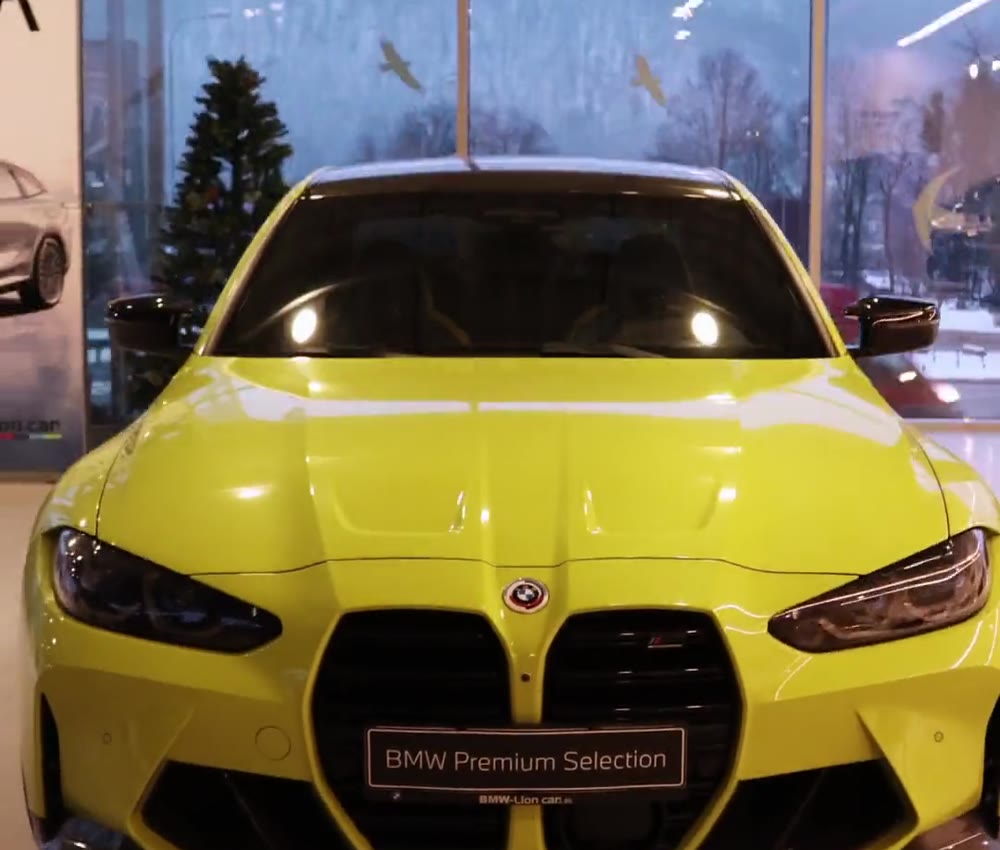 Záber z automotive videa — žlté BMW M3 Competition v showroome Lion Car